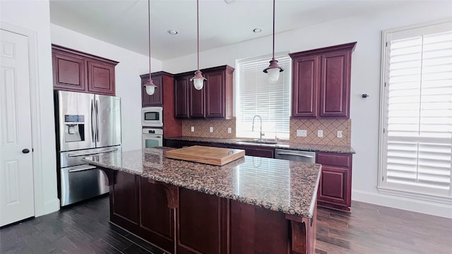 9711 Dill Canyon Ln, Katy, TX 77494 - kitchen with appliances with stainless steel finishes, dark wood-style floors, backsplash, reddish brown cabinets, and recessed lighting
