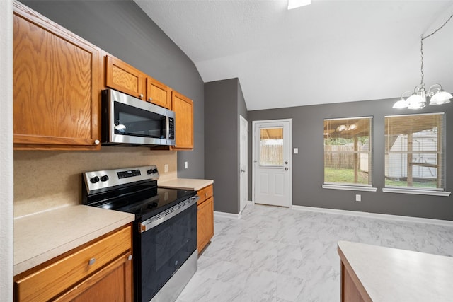 5532 N Buffalo Cir, Willis, TX 77378 - kitchen featuring stainless steel appliances, vaulted ceiling, a chandelier, light countertops, and brown cabinets