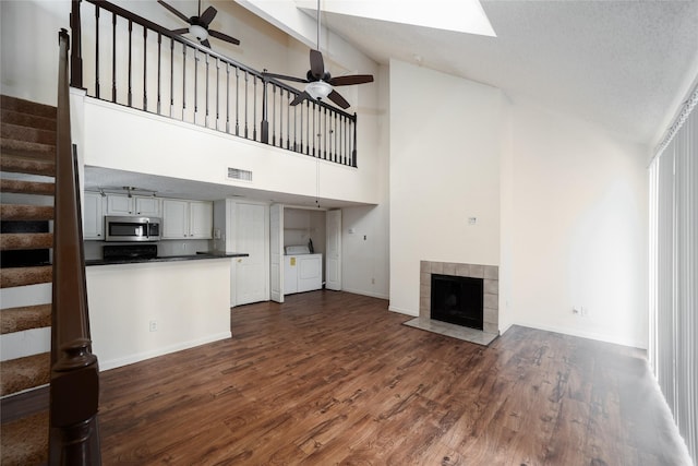 2300 Old Spanish Trl Unit 2063, Houston, TX 77054 - unfurnished living room with separate washer and dryer, ceiling fan, stairway, high vaulted ceiling, and dark wood finished floors