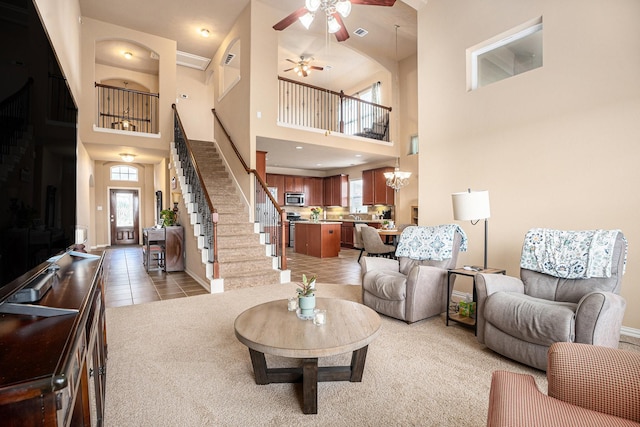 3018 Cambridge Meadows Ln, Dickinson, TX 77539 - living area featuring a high ceiling, ceiling fan, stairs, light tile patterned floors, and light carpet
