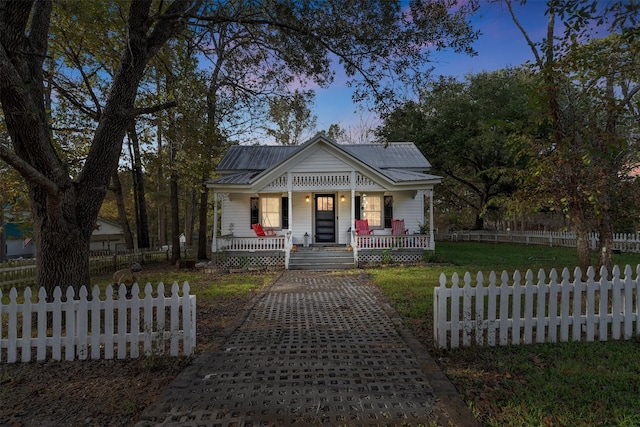91 Willow St, Point Blank, TX 77364 - bungalow-style house with covered porch, a metal roof, and a fenced front yard