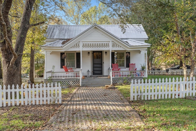 91 Willow St, Point Blank, TX 77364 - view of front of home with a porch, a metal roof, and a fenced front yard