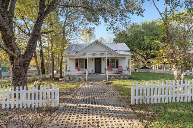 91 Willow St, Point Blank, TX 77364 - bungalow featuring a porch, a metal roof, and a fenced front yard