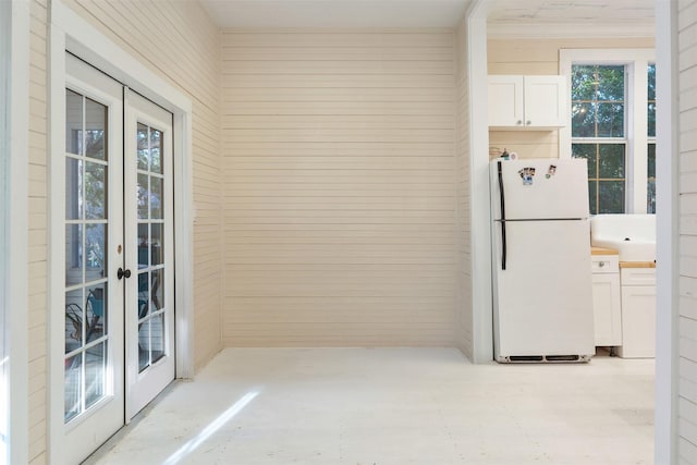 91 Willow St, Point Blank, TX 77364 - kitchen featuring freestanding refrigerator, french doors, wood walls, and white cabinetry
