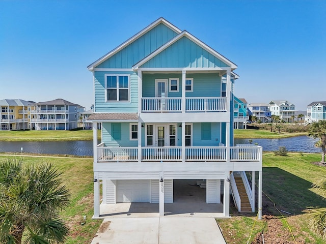 26726 Estuary Dr, Galveston, TX 77554 - rear view of house featuring a balcony, board and batten siding, a water view, and a carport