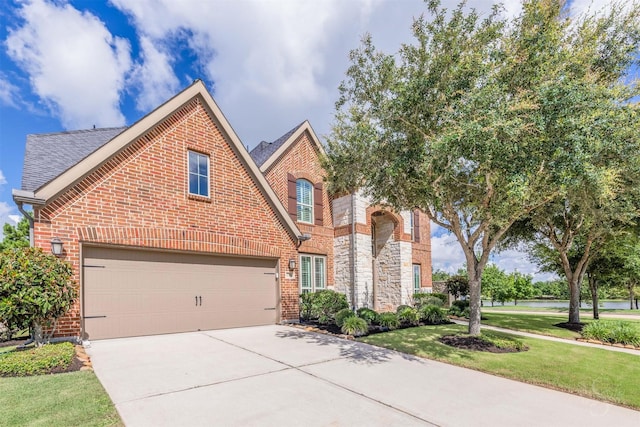 27706 Lakeway Trail Ln, Fulshear, TX 77441 - view of front facade featuring concrete driveway, brick siding, a garage, a front lawn, and a shingled roof