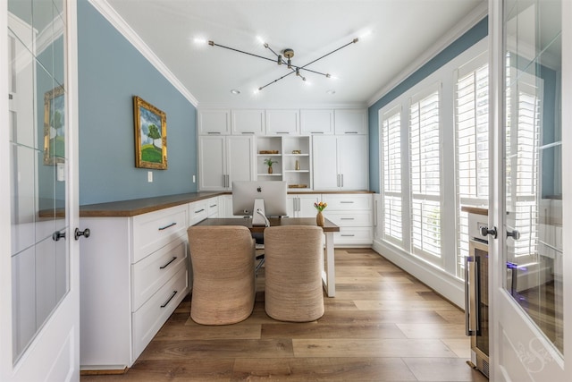 27706 Lakeway Trail Ln, Fulshear, TX 77441 - dining room with crown molding, built in desk, light wood finished floors, a chandelier, and french doors