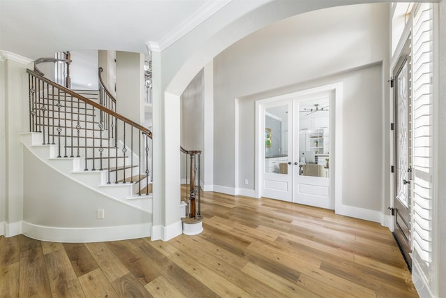 27706 Lakeway Trail Ln, Fulshear, TX 77441 - entrance foyer with arched walkways, crown molding, french doors, wood-type flooring, and stairway