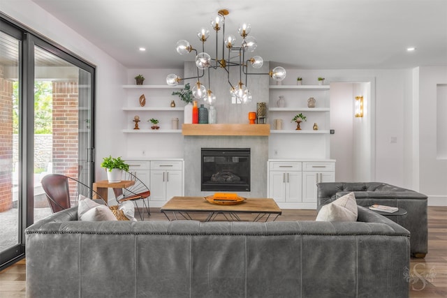 27706 Lakeway Trail Ln, Fulshear, TX 77441 - living area with wood finished floors, a fireplace, a chandelier, and built in features