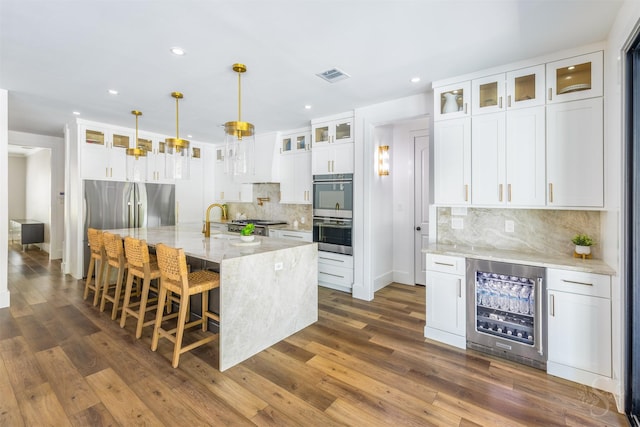 27706 Lakeway Trail Ln, Fulshear, TX 77441 - kitchen with wine cooler, double oven, backsplash, recessed lighting, and dark wood-style floors