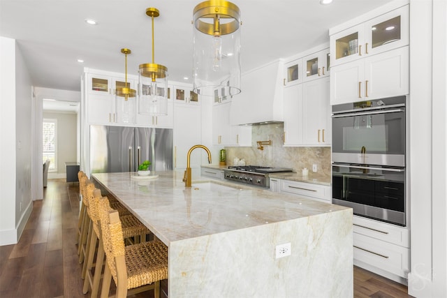 27706 Lakeway Trail Ln, Fulshear, TX 77441 - kitchen featuring appliances with stainless steel finishes, backsplash, recessed lighting, a spacious island, and dark wood-type flooring