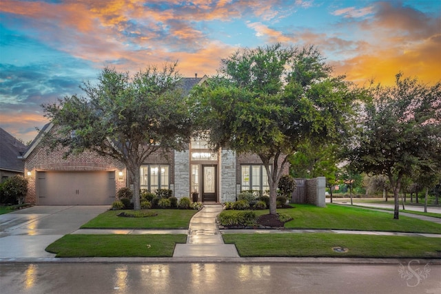 27706 Lakeway Trail Ln, Fulshear, TX 77441 - view of front facade featuring driveway, a front yard, an attached garage, and stone siding