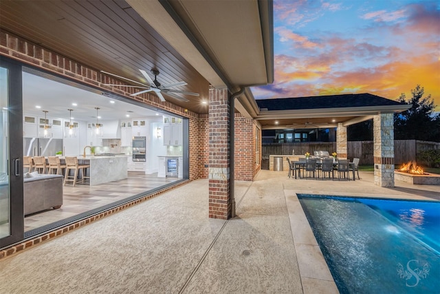 27706 Lakeway Trail Ln, Fulshear, TX 77441 - view of swimming pool featuring a ceiling fan, a patio area, an outdoor bar, and a fire pit