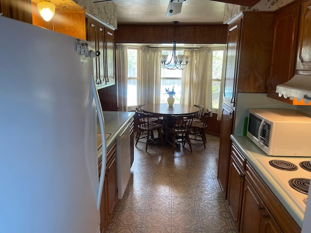 3102 Satellite Dr, San Antonio, TX 78217 - kitchen with white appliances, a chandelier, light countertops, and ventilation hood