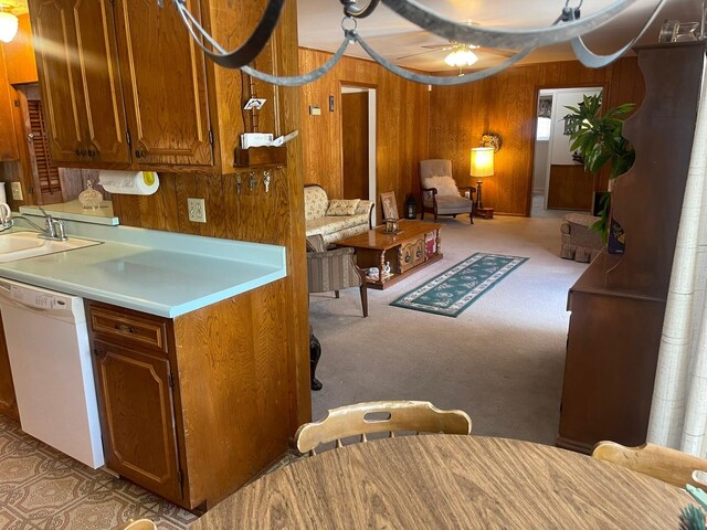 3102 Satellite Dr, San Antonio, TX 78217 - kitchen featuring dishwasher, wooden walls, brown cabinets, a ceiling fan, and light countertops