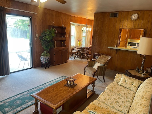 3102 Satellite Dr, San Antonio, TX 78217 - carpeted living area with wood walls, ceiling fan, healthy amount of natural light, and a chandelier