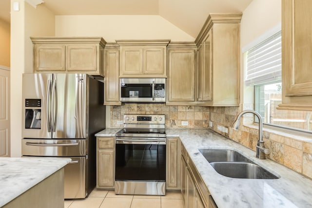 101 Brazos Ct, Richwood, TX 77531 - kitchen featuring appliances with stainless steel finishes, light stone countertops, backsplash, light brown cabinets, and vaulted ceiling