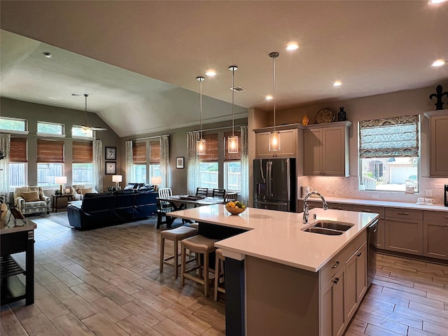 2 Ruchill Cir, Conroe, TX 77304 - kitchen with black fridge, healthy amount of natural light, open floor plan, light countertops, and vaulted ceiling