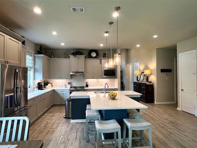 2 Ruchill Cir, Conroe, TX 77304 - kitchen featuring stainless steel appliances, a kitchen island with sink, light wood-style flooring, light countertops, and recessed lighting