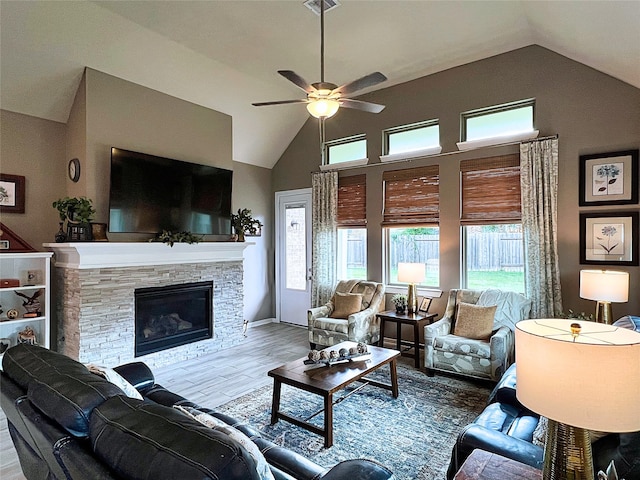 2 Ruchill Cir, Conroe, TX 77304 - living area featuring vaulted ceiling, ceiling fan, wood finished floors, and a stone fireplace