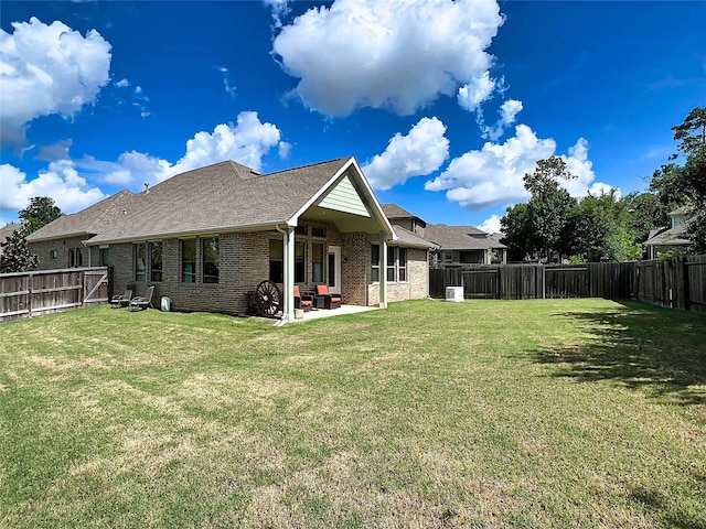 2 Ruchill Cir, Conroe, TX 77304 - back of house featuring brick siding, a patio area, a fenced backyard, and a shingled roof