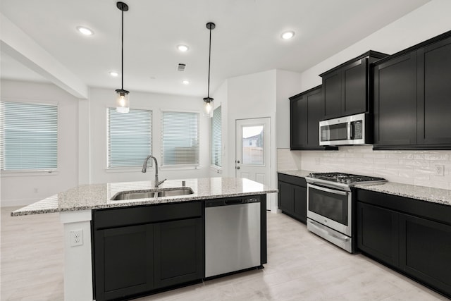 7810 Starfish Arbor Dr, Cypress, TX 77433 - kitchen featuring stainless steel appliances, dark cabinetry, tasteful backsplash, light stone countertops, and recessed lighting
