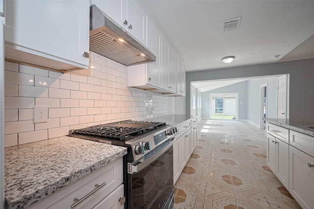 10659 Hazelhurst Dr, Houston, TX 77043 - kitchen featuring stainless steel gas range oven, under cabinet range hood, backsplash, and white cabinetry