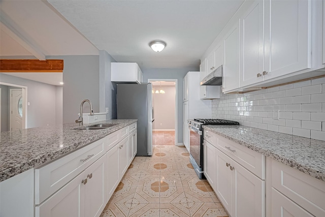 10659 Hazelhurst Dr, Houston, TX 77043 - kitchen featuring stainless steel appliances, under cabinet range hood, white cabinets, tasteful backsplash, and light tile patterned flooring