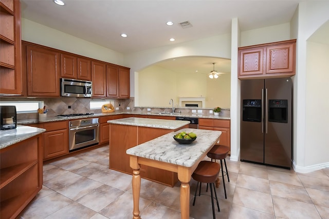 3315 Tulip Ranch Dr, Katy, TX 77494 - kitchen featuring appliances with stainless steel finishes, a ceiling fan, a center island, decorative backsplash, and recessed lighting