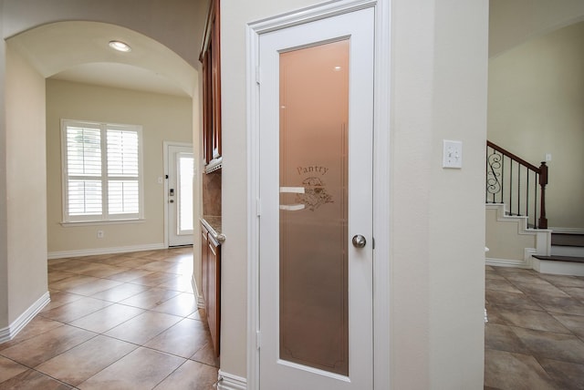 3315 Tulip Ranch Dr, Katy, TX 77494 - hallway with arched walkways, light tile patterned floors, and stairs