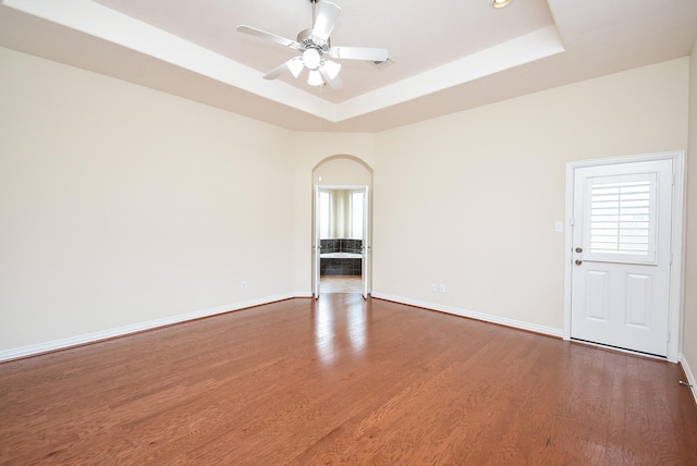 3315 Tulip Ranch Dr, Katy, TX 77494 - spare room featuring a tray ceiling, arched walkways, wood finished floors, and a ceiling fan
