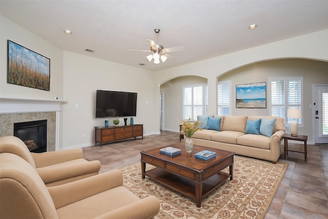 3315 Tulip Ranch Dr, Katy, TX 77494 - living room featuring arched walkways, plenty of natural light, a ceiling fan, a glass covered fireplace, and recessed lighting