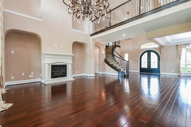 25518 Millbrook Bend Ln, Katy, TX 77494 - unfurnished living room with a chandelier, french doors, wood finished floors, stairway, and arched walkways