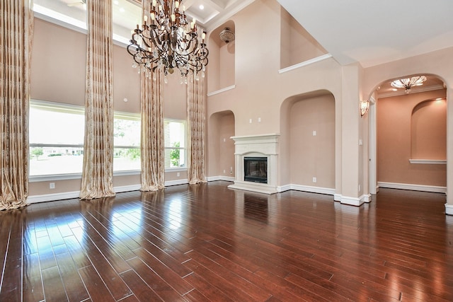 25518 Millbrook Bend Ln, Katy, TX 77494 - unfurnished living room featuring hardwood / wood-style flooring, a glass covered fireplace, arched walkways, a towering ceiling, and ornamental molding