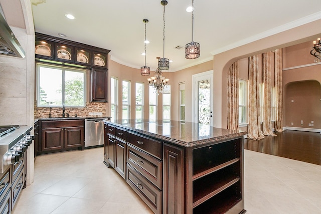 25518 Millbrook Bend Ln, Katy, TX 77494 - kitchen featuring appliances with stainless steel finishes, a chandelier, wall chimney exhaust hood, arched walkways, and tasteful backsplash