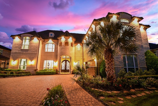 25518 Millbrook Bend Ln, Katy, TX 77494 - french country inspired facade featuring french doors, driveway, and stucco siding