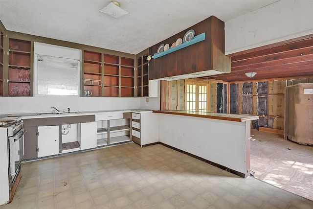 531 Circle Dr, La Porte, TX 77571 - kitchen featuring open shelves, light flooring, gas stove, and a peninsula