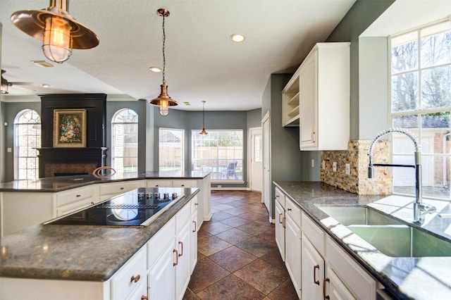 11715 Orchard Mountain Dr, Pasadena, TX 77059 - kitchen with black electric stovetop, a center island, backsplash, recessed lighting, and white cabinetry