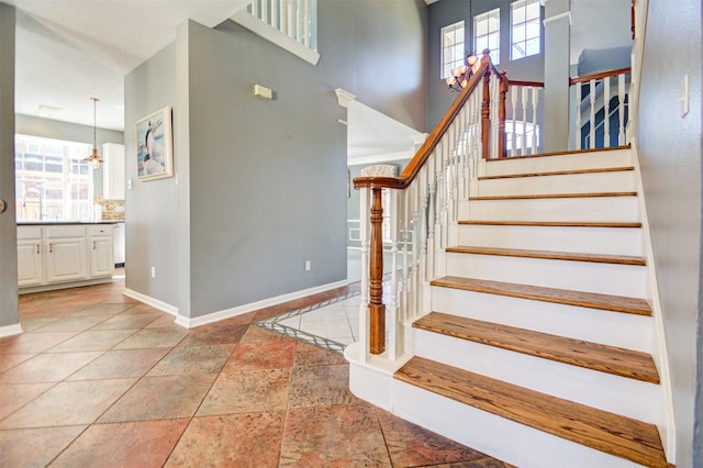 11715 Orchard Mountain Dr, Pasadena, TX 77059 - stairway with healthy amount of natural light, a chandelier, a high ceiling, and stone tile floors