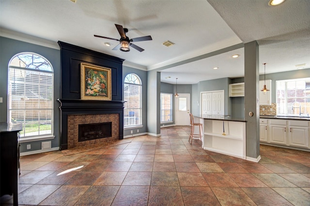 11715 Orchard Mountain Dr, Pasadena, TX 77059 - unfurnished living room featuring a ceiling fan, ornamental molding, a large fireplace, recessed lighting, and a textured ceiling