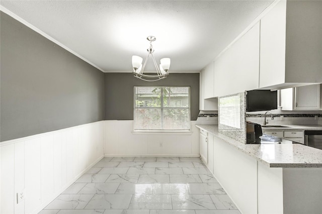 224 Maddox St, Clute, TX 77531 - unfurnished dining area featuring light marble finish flooring, a chandelier, wainscoting, and ornamental molding
