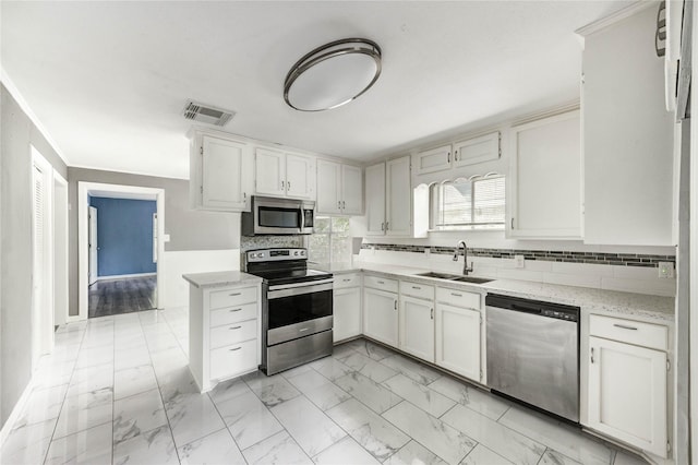 224 Maddox St, Clute, TX 77531 - kitchen with stainless steel appliances, light marble finish flooring, tasteful backsplash, white cabinetry, and light stone counters
