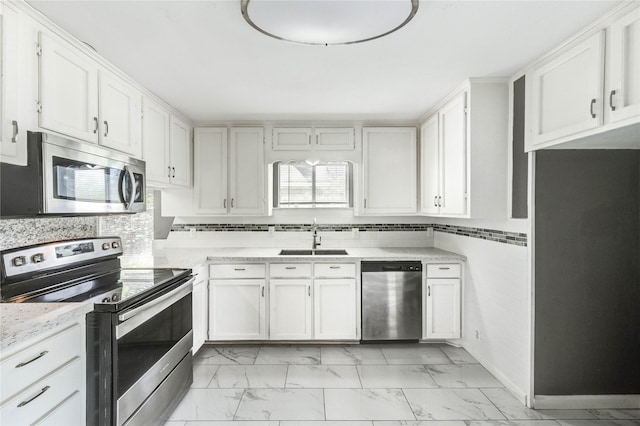 224 Maddox St, Clute, TX 77531 - kitchen with stainless steel appliances, light marble finish floors, white cabinetry, and backsplash