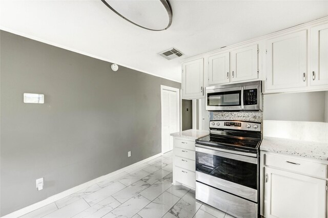 224 Maddox St, Clute, TX 77531 - kitchen featuring appliances with stainless steel finishes, white cabinetry, light marble finish floors, light stone countertops, and crown molding