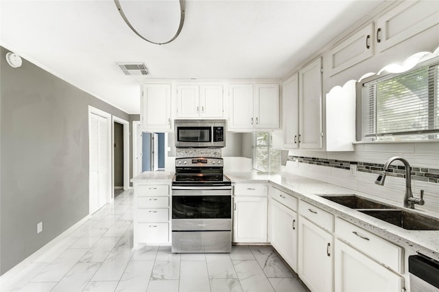 224 Maddox St, Clute, TX 77531 - kitchen featuring appliances with stainless steel finishes, light marble finish flooring, backsplash, white cabinetry, and light stone countertops