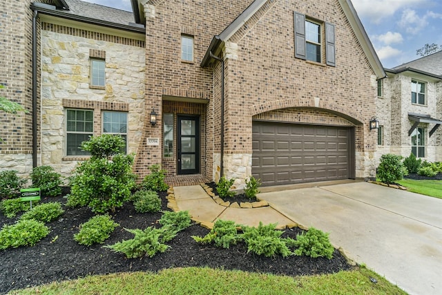 17794 Misty Brook Ln, Conroe, TX 77302 - view of front of house with stone siding, driveway, an attached garage, and brick siding