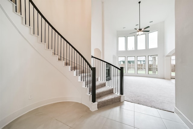 17794 Misty Brook Ln, Conroe, TX 77302 - staircase with carpet flooring, a towering ceiling, ceiling fan, and tile patterned flooring