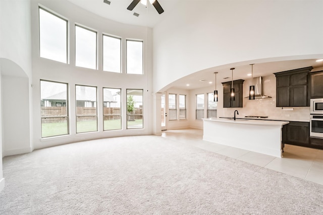 17794 Misty Brook Ln, Conroe, TX 77302 - kitchen featuring wall chimney range hood, open floor plan, light colored carpet, white appliances, and ceiling fan