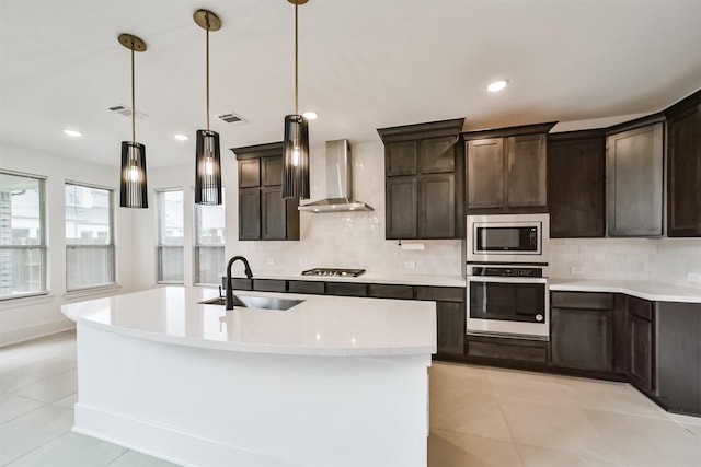17794 Misty Brook Ln, Conroe, TX 77302 - kitchen with appliances with stainless steel finishes, wall chimney range hood, decorative backsplash, light countertops, and dark brown cabinetry