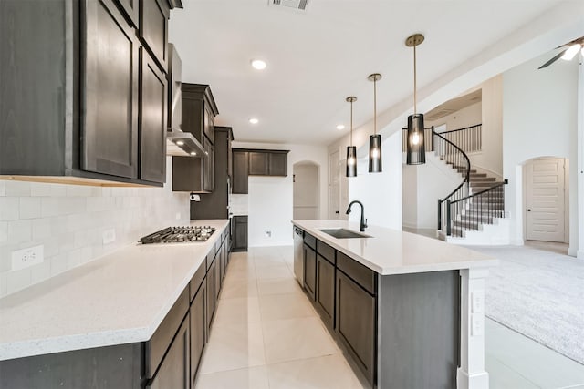 17794 Misty Brook Ln, Conroe, TX 77302 - kitchen with appliances with stainless steel finishes, tasteful backsplash, arched walkways, dark brown cabinetry, and light countertops